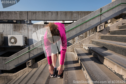 Image of woman  stretching before morning jogging