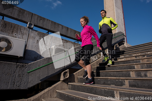 Image of young  couple jogging on steps