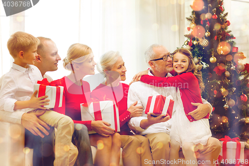 Image of smiling family with gifts at home