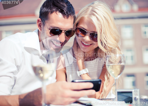 Image of couple looking at smartphone in cafe