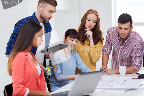 Image of creative team with blueprint working at office