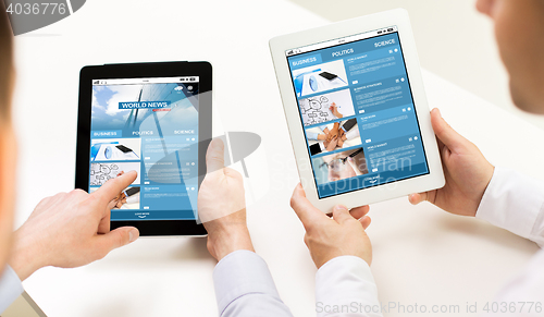 Image of close up of hands with business news on tablet pc