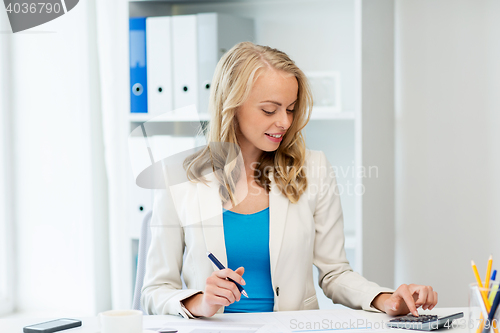 Image of businesswoman with calculator counting at office