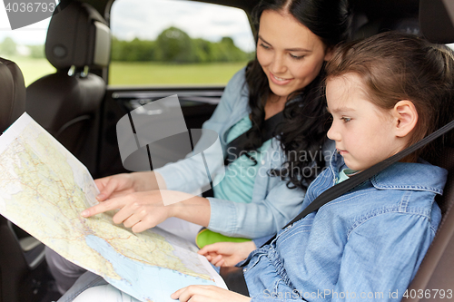 Image of happy family with travel map driving in car