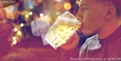 Image of close up of young man drinking beer from glass mug