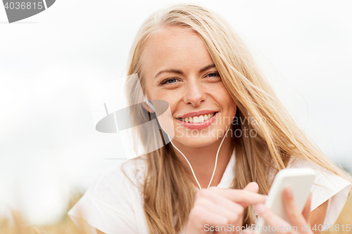 Image of happy woman with smartphone and earphones