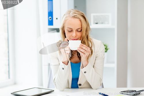 Image of happy businesswoman drinking coffee at office