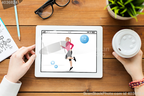 Image of close up of woman with fitness app on tablet pc