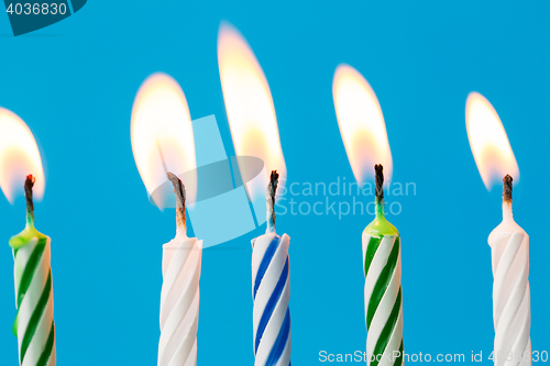 Image of birthday candles burning over blue background