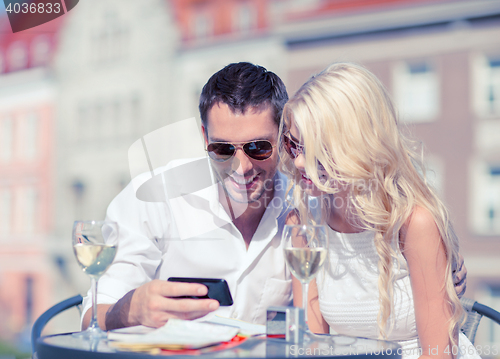 Image of couple looking at smartphone in cafe