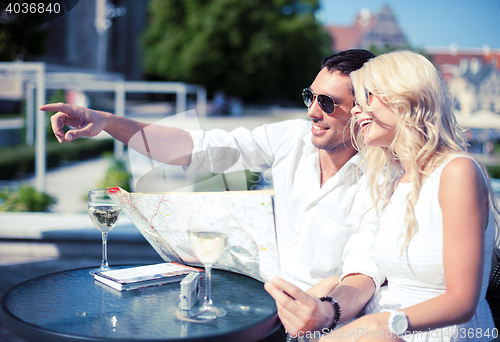 Image of couple with map in cafe