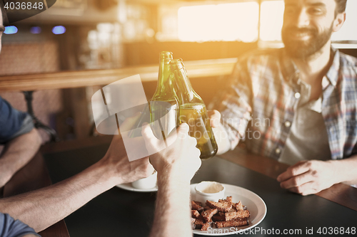 Image of happy male friends drinking beer at bar or pub