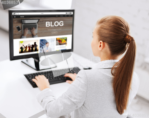 Image of businesswoman with computer blogging at office