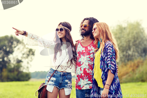 Image of smiling young hippie friends on green field