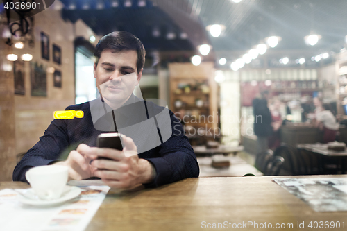 Image of Gentleman sitting at the table using phone