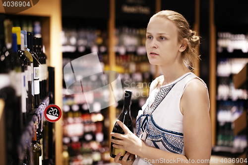 Image of Woman shopping for alcohol in a bottle store