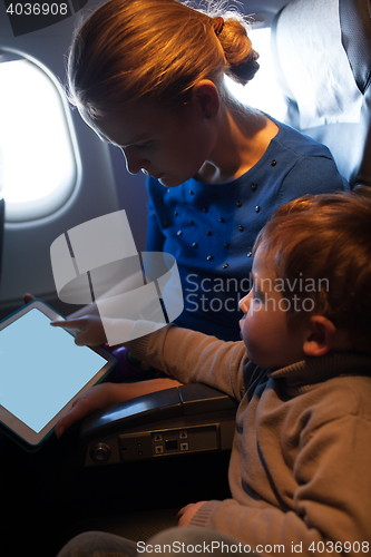 Image of Mother traveling on a plane with her small son