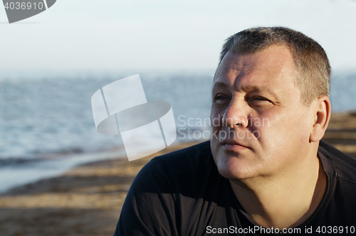 Image of Handsome middle-aged man thinking at the beach