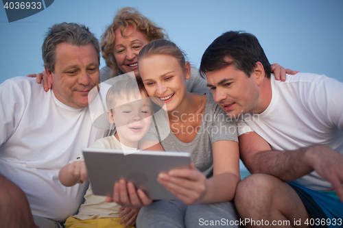 Image of Happy family spending time with pad outdoor