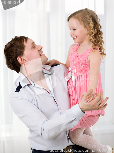 Image of Father holding daughter and they dancing