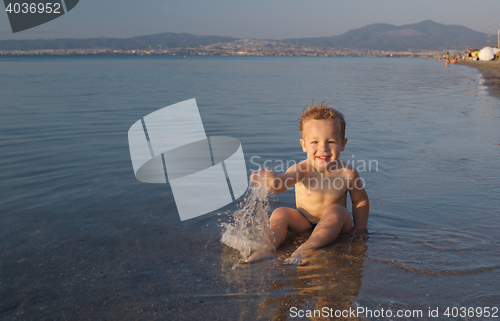 Image of Cute little boy splashing in the sea