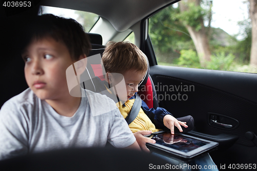 Image of Two boys traveling on the back seat of a car