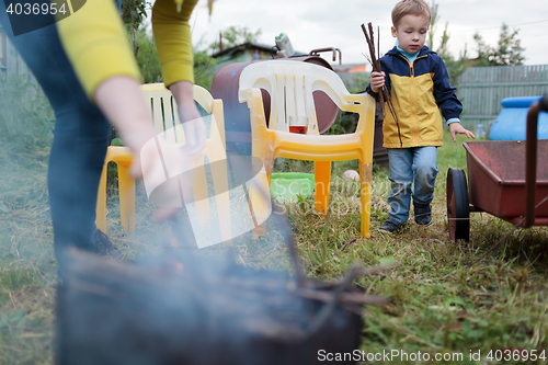 Image of Mother and son making fire in the yard