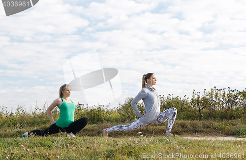 Image of Two young girls exercising outdoors