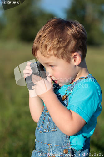 Image of Little child taking pictures outdoor