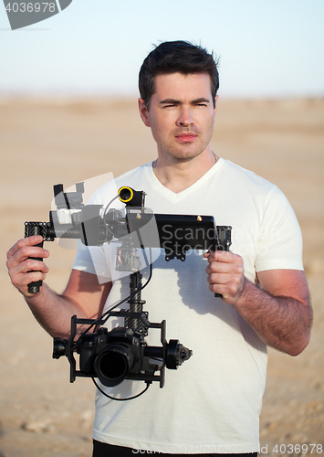 Image of Videographer with steadicam equipment on the beach