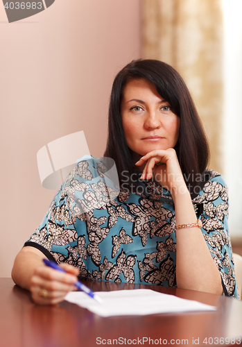 Image of Attractive middle-aged woman working at home