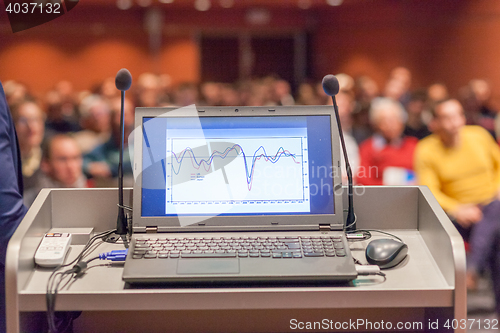 Image of Computer and microphone on rostrum at business event.