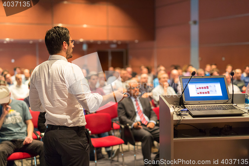 Image of Public speaker giving talk at Business Event.