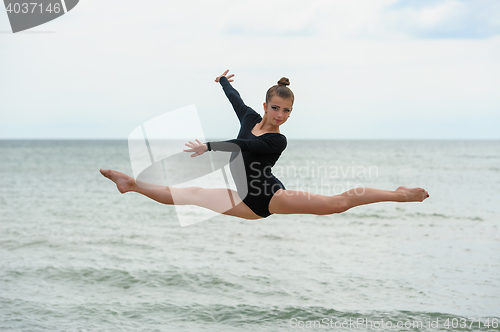 Image of Gymnast Dancer Jumping On The Sea Beach