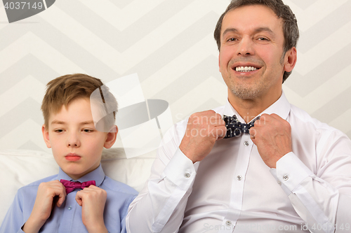 Image of Father and son adjusting bowties