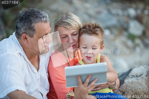 Image of Grandparents and grandson with tablet PC outdoor