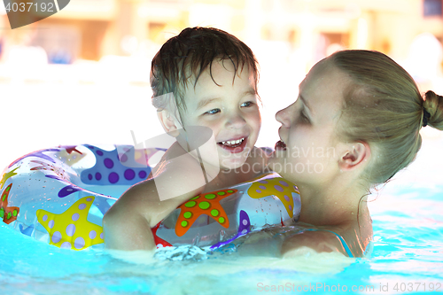 Image of Mother and her son in the outdoor swimming pool