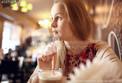 Image of Girl is looking through the window in cafe.