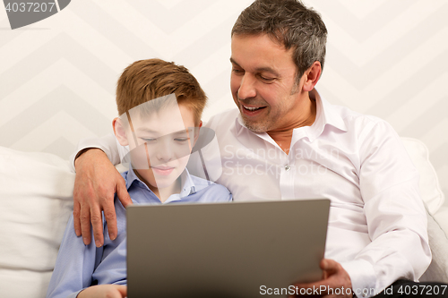 Image of Boy and father using laptop together