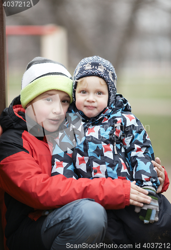 Image of Two adorable young brothers outdoors in winter