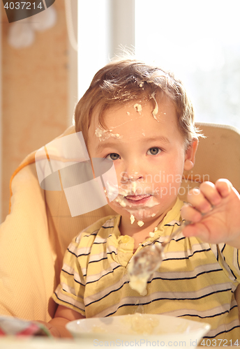 Image of Two year old boy eats porridge in the morning.