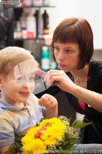 Image of Young boy getting haircut from styist