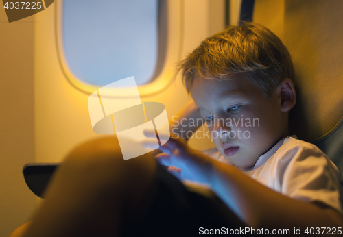 Image of Little boy using tablet computer during flight