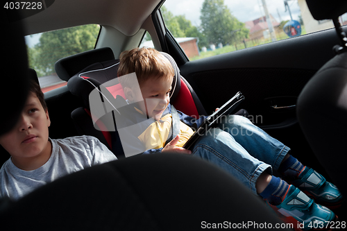 Image of Two boys on the back seat of a car