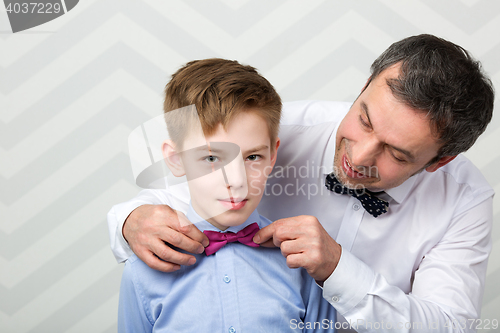 Image of Father adjusting sons bowtie