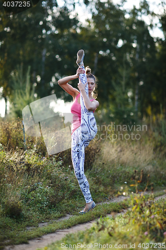 Image of Athletic young woman working out in the country