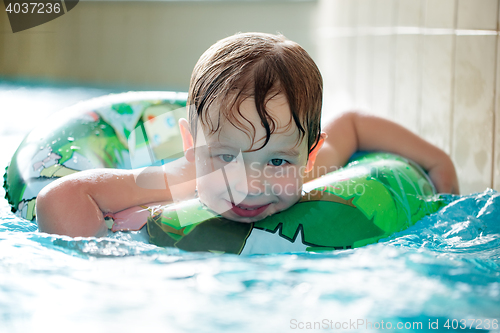 Image of Young boy in inflatable tube swimming