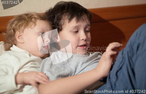 Image of Two young children playing with a tablet