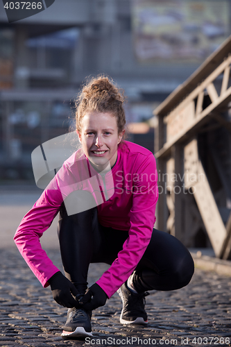 Image of woman  stretching before morning jogging