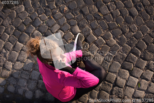 Image of woman  stretching before morning jogging